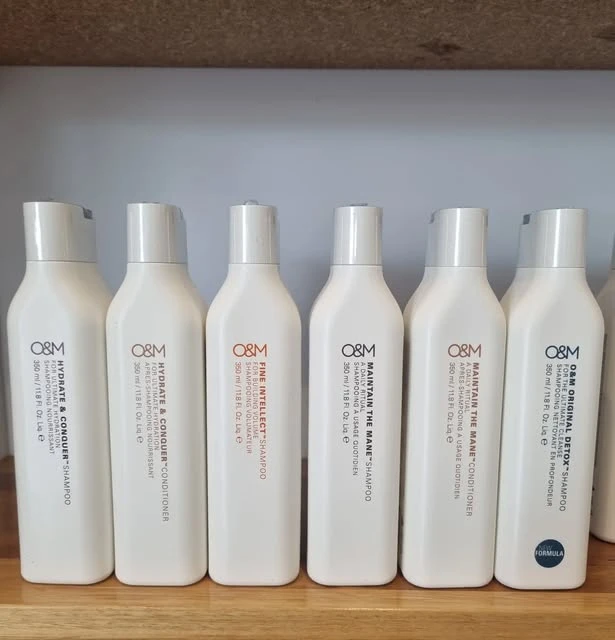 Original & Mineral (O&M) ammonia-free range on the Curly Belle salon shelf — Hydrate & Conquer, Fine Intellect, Maintain the Mane, Original Detox