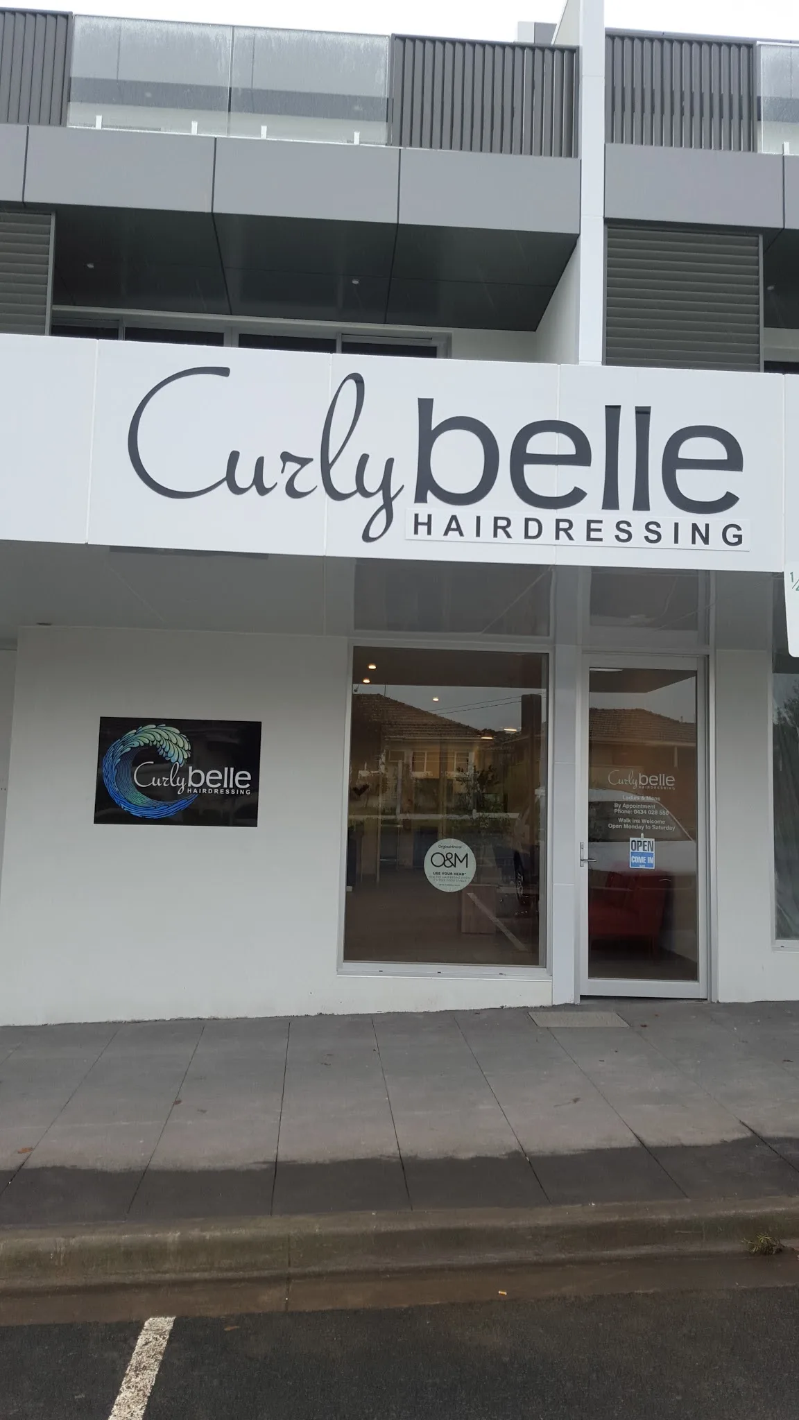 Curly Belle shopfront door — 'By Appointment · Walk ins Welcome · Open Monday to Saturday'
